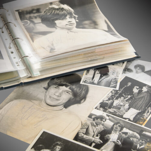 Collection of Rolling Stones signed Photographs spread out with a binder open full of more signed photos.